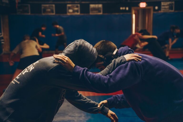 Deux sportifs en corps-à-corps à l'entraînement, mains sur la nuque de l'autre