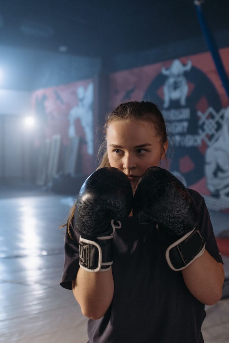 Boxeuse en garde haute, les deux gants devant le visage