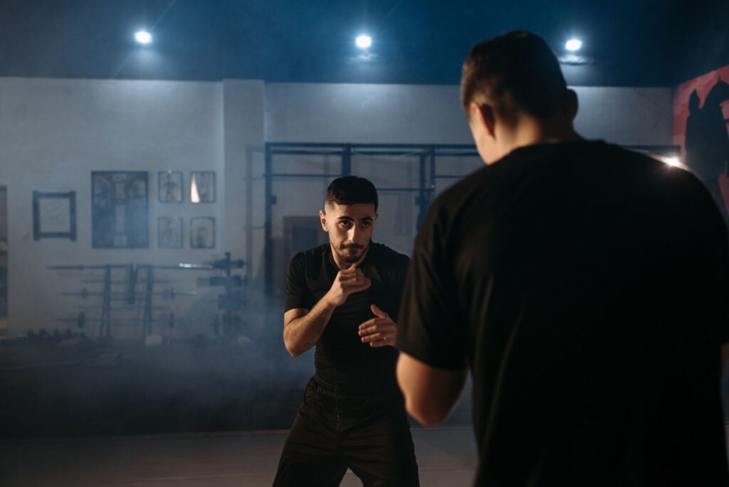 Deux pratiquants en tenue noire face a face dans une salle d'entrainement