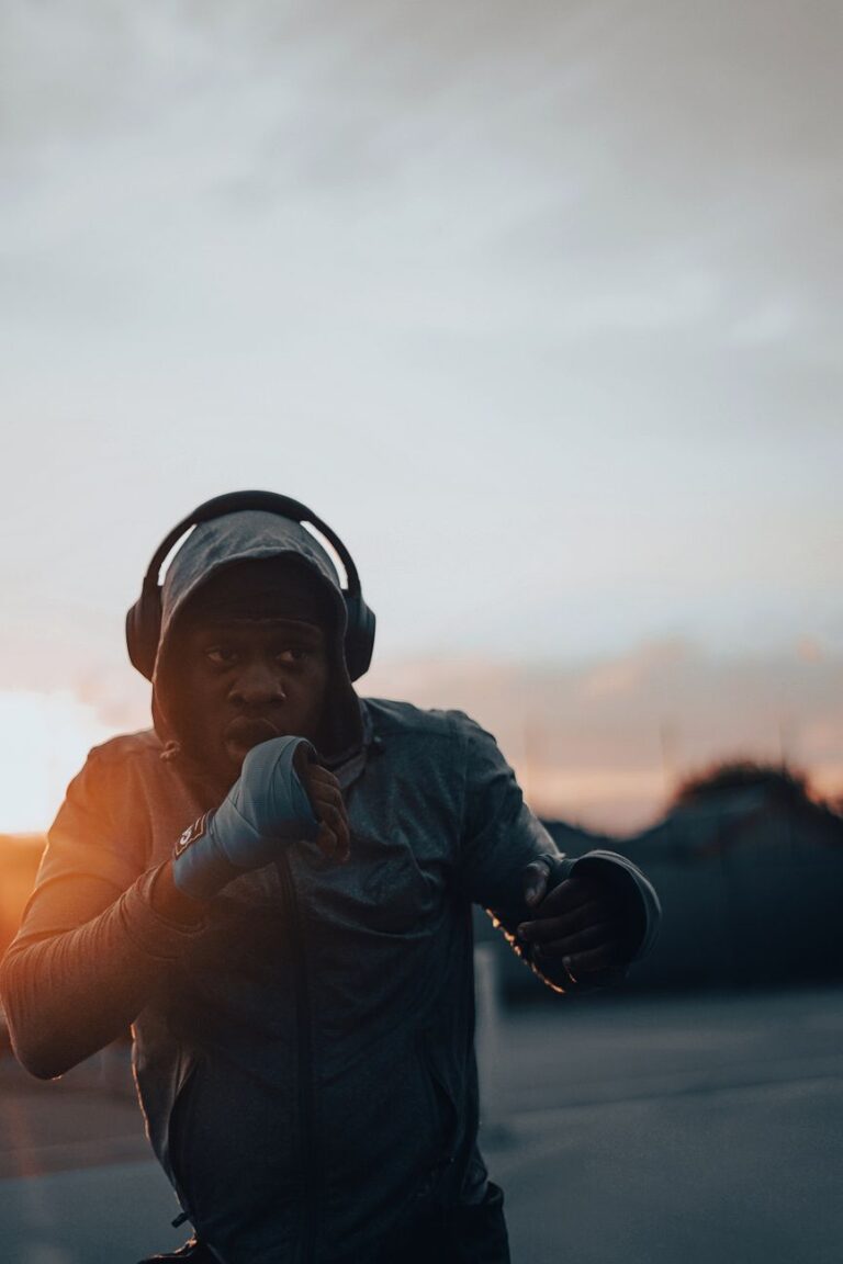 Sportif qui fait du shadow boxing en plein air au coucher du soleil