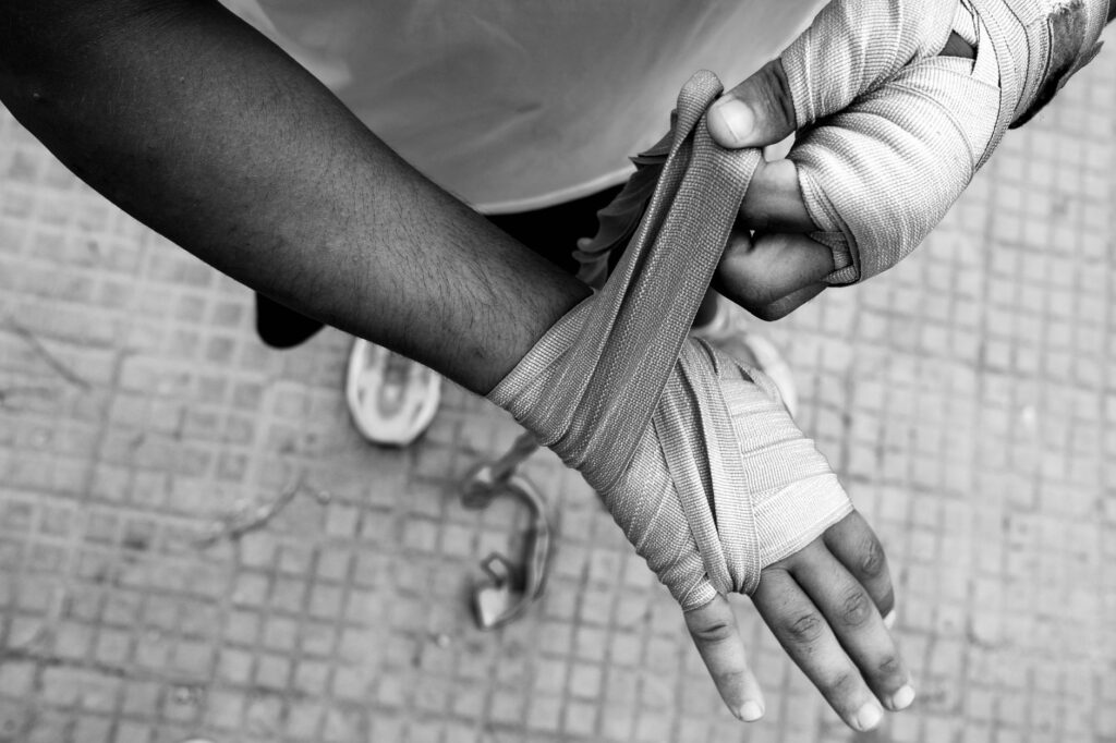 Mains d'un boxeur en cours de bandage, gros plan sur le poignet