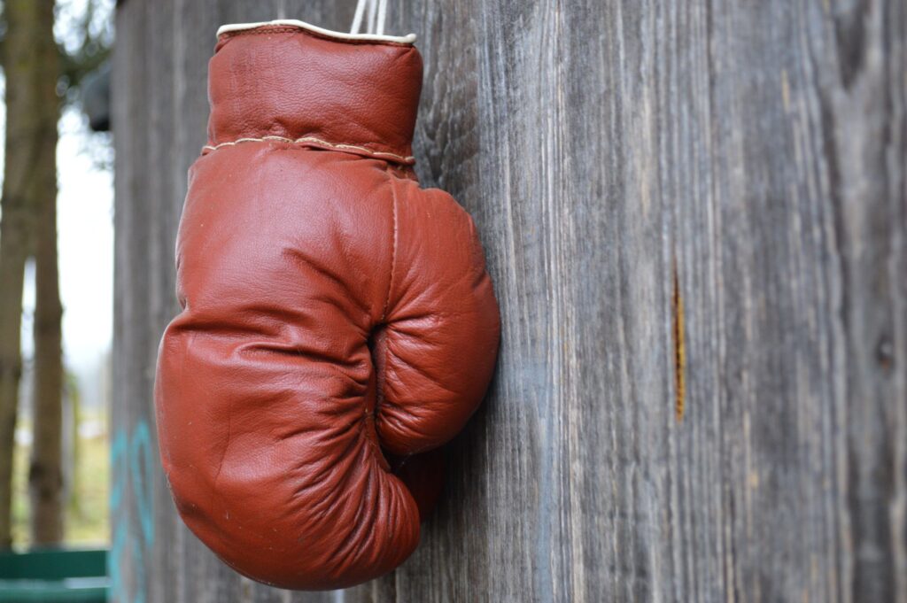Gant de boxe en cuir rouge suspendu à un mur en bois