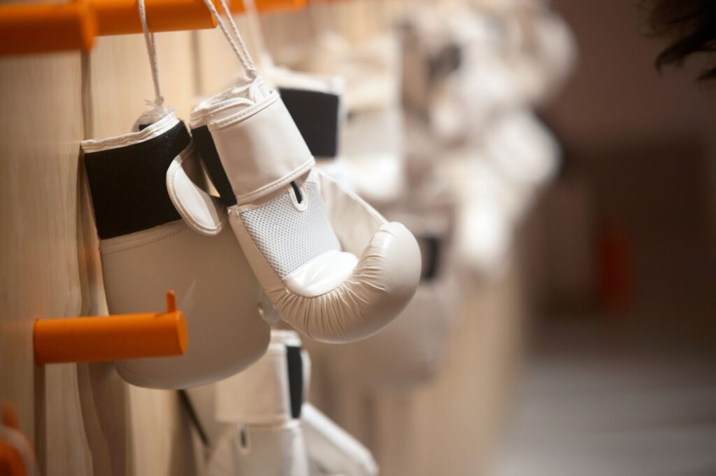 Gants de boxe blancs suspendus à un portant dans une salle d'entraînement
