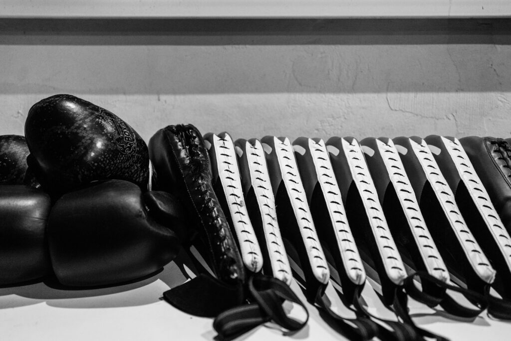 Rangée de gants de boxe alignés sur une étagère, photo en noir et blanc